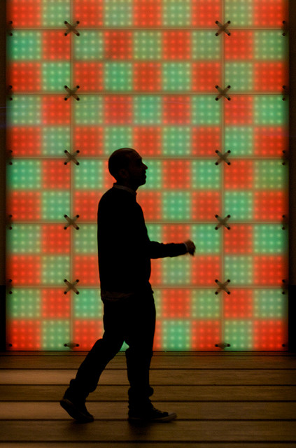 Silhouette of man in front of red and green wall