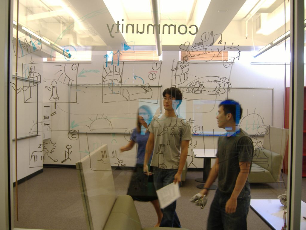 Students working behind a glass board on an entrepreneurship model