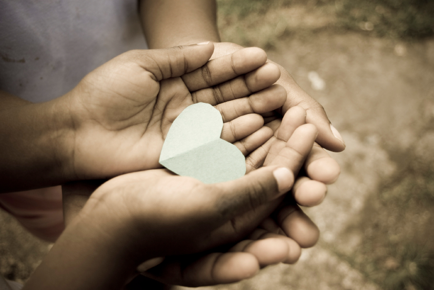 Photo - Child's hands holding paper heart.